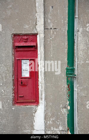 Alten viktorianischen Postbox in die Wand des Hauses neben einem grünen Fallrohr, Rhandirmwyn, Llandovery, Carmarthenshire, Wales montiert. Stockfoto