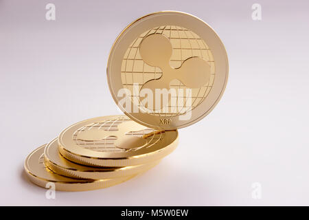 Auf den weißen Hintergrund sind Goldmünzen eines digitalen crypto Währung - restwelligkeit xrp. Auf der schiefen Ebene aus drei Münzen auf einer Seite platziert, t Stockfoto
