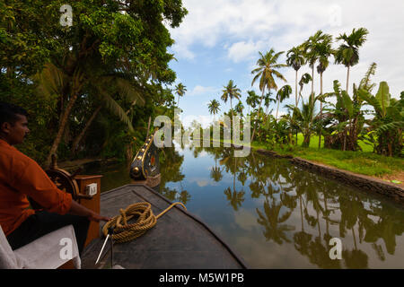 Der Steuermann der Lenkung auf einem Hausboot auf den Backwaters in der Nähe von Alleppey und Kumarakom in Kerala, Indien. Stockfoto