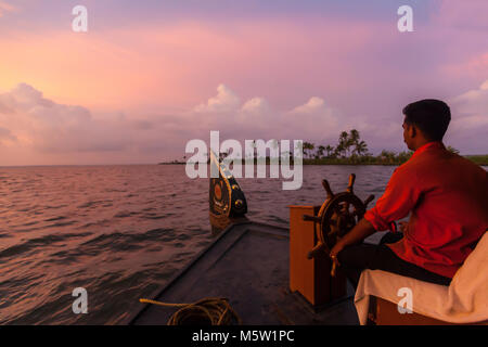 Der Steuermann der Lenkung auf einem Hausboot auf den Backwaters in der Nähe von Alleppey und Kumarakom in Kerala, Indien. Stockfoto