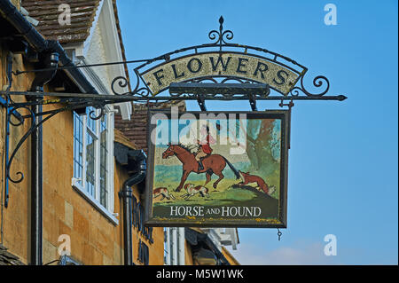 Alte pub anmelden Werbung Blumen ales hängen von einem Pub in den Cotswolds Stadt des Broadway. Der Pub Schild zeigt ein Bild von einer Jagd Pferd und Hund Stockfoto