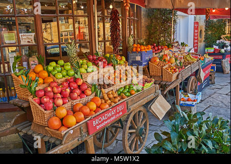 Altmodische Obst und Gemüse Barrow zeigt eine breite Palette von frischem Obst und Gemüse außerhalb der lokalen deli Store in Broadway, Worcestershire Stockfoto