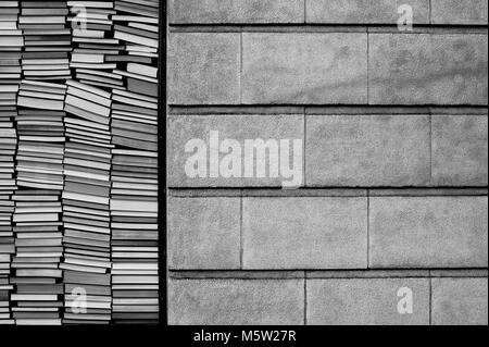 Bücher gegen Fenster mit Ziegel Wand neben Stapeln Stockfoto