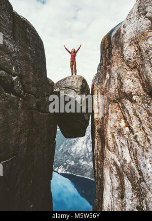 Frau Tourist auf Kjeragbolten erhobenen Händen Reisen in Norwegen Kjerag bergen extreme Ferien Abenteuer touristische glücklich Emotionen erfolg konzept Stockfoto