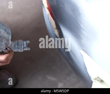 Auto Body Shop, Arbeiter Malerarbeiten ist fest Stoßfänger Stockfoto