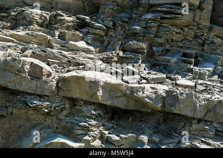 Close-up diagonal geschichtetes Gestein mit großen und kleinen Steinen. Stockfoto