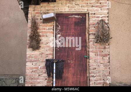 Mop auf einer hölzernen Tür (Yunnan, China) Stockfoto