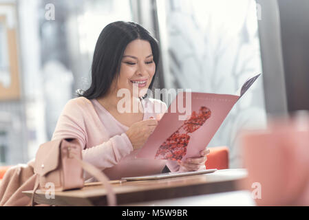 Schöne angenehme Frau Artikel lesen Stockfoto