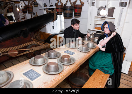 Laid Chaos Tisch und zwei historische Zeichen von Schauspielern, die Gespräche geben Sie Kindern gespielt. HMS Warrior. Portsmouth Historic Dockyard. UK. (95) Stockfoto
