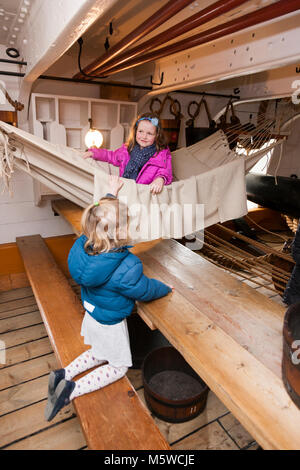 Touristische spielen die Kinder auf Hängematte aufgehängt zwischen 68 Pounder Beförderung Gewehren auf die HMS Warrior, Portsmouth Historic Dockyard/historischen Werften. UK. (95) Stockfoto