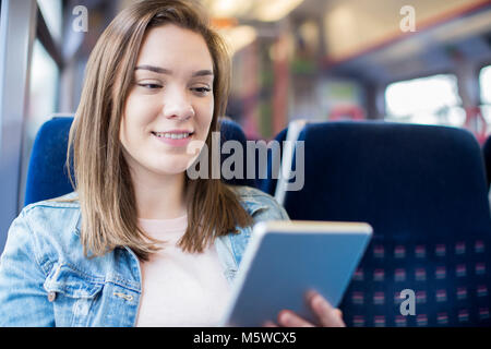 Junge Frau mit digitalen Tablet während der Zugfahrt Stockfoto