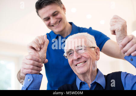 Männliche Krankenschwester Bewertung Senior Schlaganfall Opfer durch Anheben der Arme Stockfoto