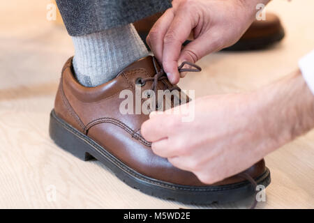 In der Nähe von erwachsenen Sohn helfen älteren Menschen Tie Shoelaces Stockfoto