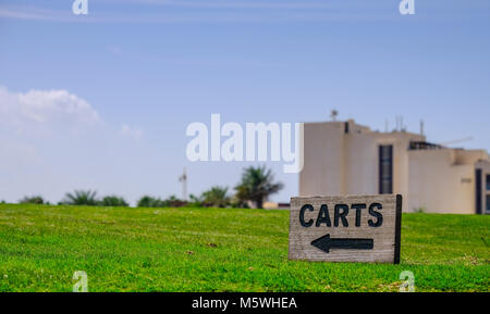Einen kleinen hölzernen Karren Schild mit Pfeil am Golfplatz Saadiyat Beach Golf Club links Stockfoto