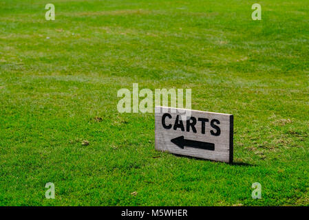 Einen kleinen hölzernen Karren Schild mit Pfeil am Golfplatz Saadiyat Beach Golf Club links Stockfoto