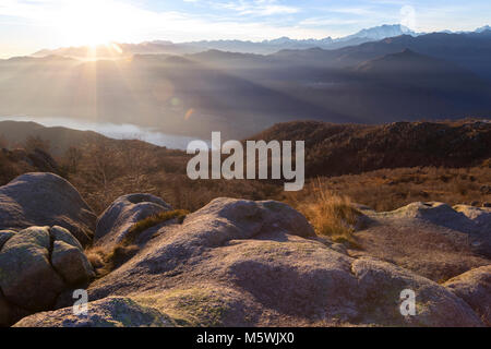 Blick auf den Monte Rosa und Lago d'Orta, die aus einer Gruppe von Felsen an der Oberseite des Mottarone. Stresa, Verbano Cusio Ossola, Piemont, Italien. Stockfoto