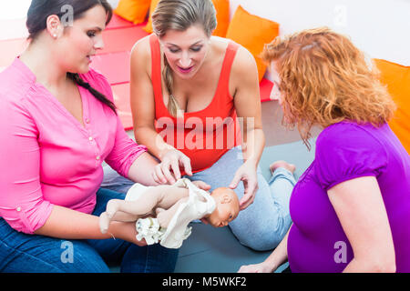 Hebamme erklärt Geburt für schwangere Frauen während der Geburt liegenden Klasse Stockfoto