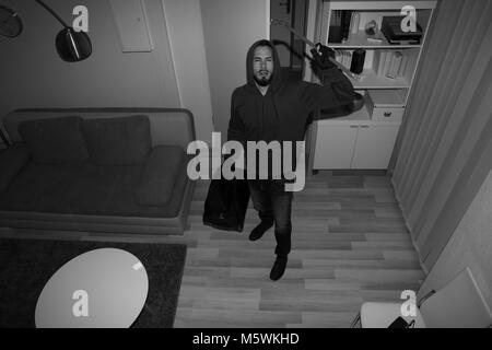 Hohe Betrachtungswinkel eines Räuber brechen CCTV Kamera im Freien Haus Stockfoto