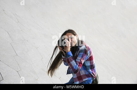 Junge Fotografin auf grauem Hintergrund Stockfoto