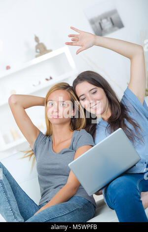 Zwei glückliche Freunde lachen Sie Medien in einem Laptop Stockfoto