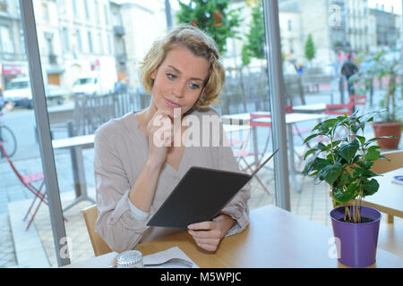 Frau Suchen im Menü für die Bestellung von Essen im Restaurant Stockfoto