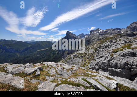 Blick auf die Berge aus den Kantabrischen Bergen, Nordspanien. Felsiger Vordergrund der Bergkette mit blauem Himmel und Wolken. Stockfoto