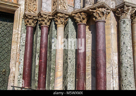 Säulen und Kapitellen aus verschiedenen Arten von Marmor auf dem San Marco Basilika Fassade. In der Stadt Venedig, die historische und fantastische Marine City. Stockfoto