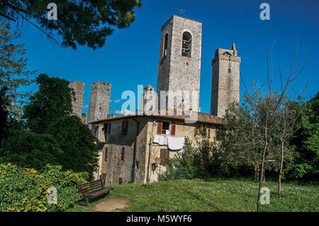 Aussicht auf die Dächer und Türme mit Garten in San Gimignano. Eine mittelalterliche Stadt mit mehreren Türmen. Stockfoto