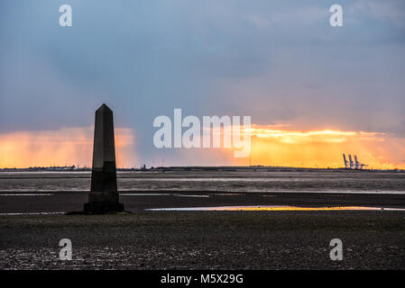 Schnee kam in der Abenddämmerung im Southend Borough an, als die Sonne hinter dem Crowstone in Chalkwell, Essex, Großbritannien unterging. Themsenmündung bei Ebbe. PLA-Grenzmarkierung Stockfoto