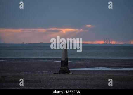 Schnee kam in der Abenddämmerung im Southend Borough an, als die Sonne hinter dem Crowstone in Chalkwell, Essex, Großbritannien unterging. Themsenmündung bei Ebbe. PLA-Grenzmarkierung Stockfoto