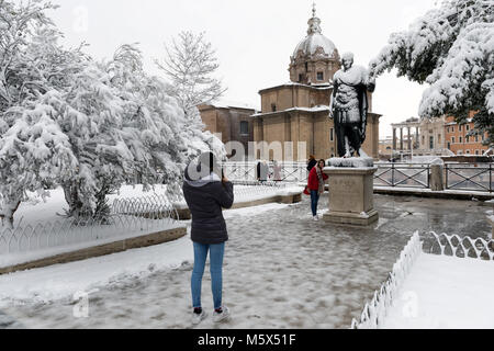 Rom, Italien. 26 Feb, 2018. Eine außergewöhnliche Wetter Ereignis verursacht eine kalte und warme Luft in ganz Europa, auch aus Italien. Der Schnee kommt in die Hauptstadt, Straßen und Denkmäler von einem weißen weißen Mantel. In der Abbildung sind einige Leute fotografieren selbst vor der Statue von Julius Caesar im Schnee. Credit: Polifoto/Alamy leben Nachrichten Stockfoto