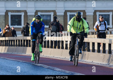 Menschen und Radfahrer Kreuzung London Bridge an einem kalten Wintermorgen, London, England, Vereinigtes Königreich, Großbritannien Stockfoto