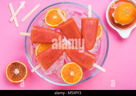 Orangensaft gesunde Eis am Stiel über Eiswürfel. Stockfoto