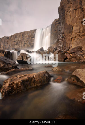 Wasserfall Öxarárfoss, Island. Felsiger Vordergrund mit langer Belichtung und weichem Wasserporträt Stockfoto