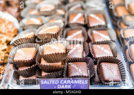 Makro Nahaufnahme von Schokolade dunkel gesalzen Karamellbonbons Plätze bars Candy süße Nachspeise behandelt mit Vorzeichen auf Fach Anzeige in Store, Shop, Bäckerei, Cafe Stockfoto