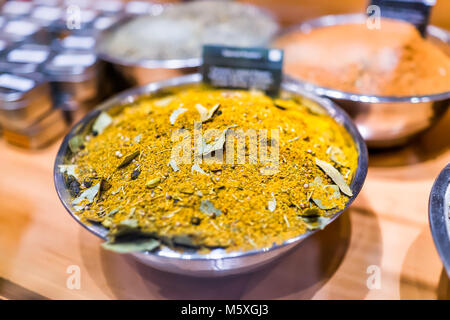 Nahaufnahme von Gewürzen auf der Anzeige in der Schüssel Fach gefüllt mit Grün Gelb Orange curry Lorbeerblätter mix Stockfoto