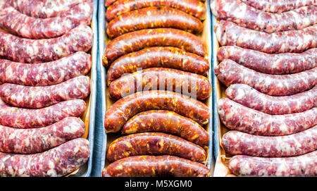 Flach nach unten Top view Muster von vielen rohen handwerkliche Wurst rosa, rot, orange Chorizo closeup auf Tablett im Markt für frische butcher shop shop Stockfoto