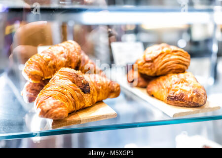 Nahaufnahme von reiner Butter golden gebackene knusprige Croissants auf Glas Regal Anzeige desserts Süßigkeiten in Bäckerei cafe store Stapel Stapel Stockfoto