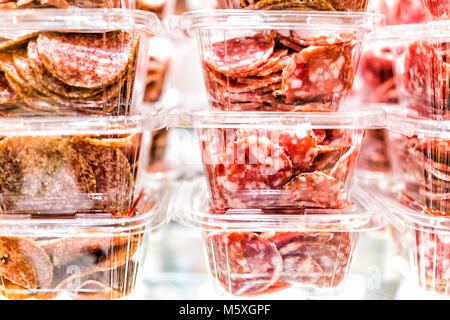 Nahaufnahme des sopressata und Genua Salami schneiden viele Schichten in Kunststoffbehälter Behälter Stapel auf Fachanzeige in einem Markt shop Metzger Stapel Stockfoto