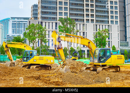 Bagger graben Boden an Industrie in Singapur Stockfoto