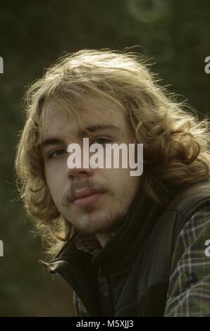 Junge britische Woodsman mit robusten, schöne lange blonde Haare. Exeter, Devon, Großbritannien. Stockfoto