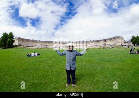 Junge Smart Casual Mann vorgibt, den Royal Crescent der Badewanne auf seinen Händen halten. Stadt Bath, Somerset, UK. Sommer, 2017. Stockfoto