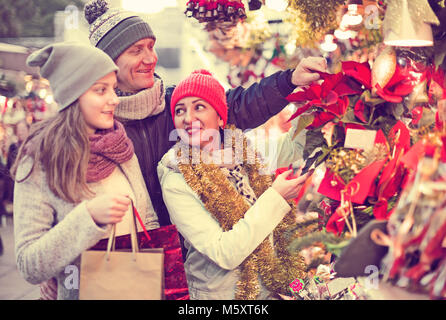 Bezaubernde Familie von drei Wahl Weihnachten Stern Blume am Weihnachtsmarkt Stockfoto