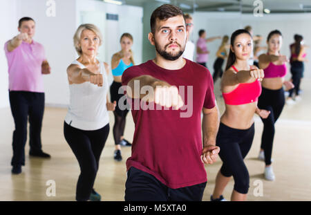 Glücklich lächelnde Schlank athletische Frauen und Männer tanzen Streifen aus Kunststoff in der Klasse Stockfoto