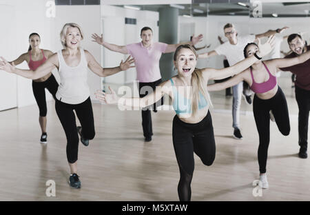 Positive lächelnde Schlank athletische Frauen und Männer tanzen Streifen aus Kunststoff in der Klasse Stockfoto