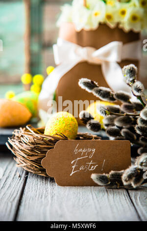 Ostereier auf Holz. Bunte Ostern Konzept mit Eier in wisker Warenkorb in der Natur Stockfoto