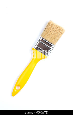 Gelbe Farbe und Pinsel auf einem weißen Hintergrund. Industrielle Pinsel mit Holzgriff. Stockfoto