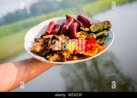 Sortierte leckeres Gegrilltes Fleisch mit Gemüse über die Kohlen auf einem Grill Stockfoto