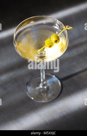 Glas mit Martini und grüne Oliven, Oliven Fokus Stockfoto