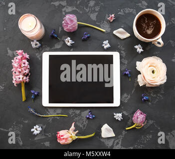 Festliche Einladung Karte mit schönen Blumen, Kerze, Tablet-PC und Tasse Kaffee auf dem dunklen Hintergrund Stockfoto